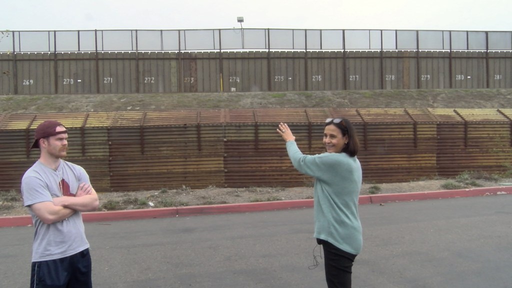 Norma Iglesias Prieto speaks in front of the border wall. located in a shopping mall